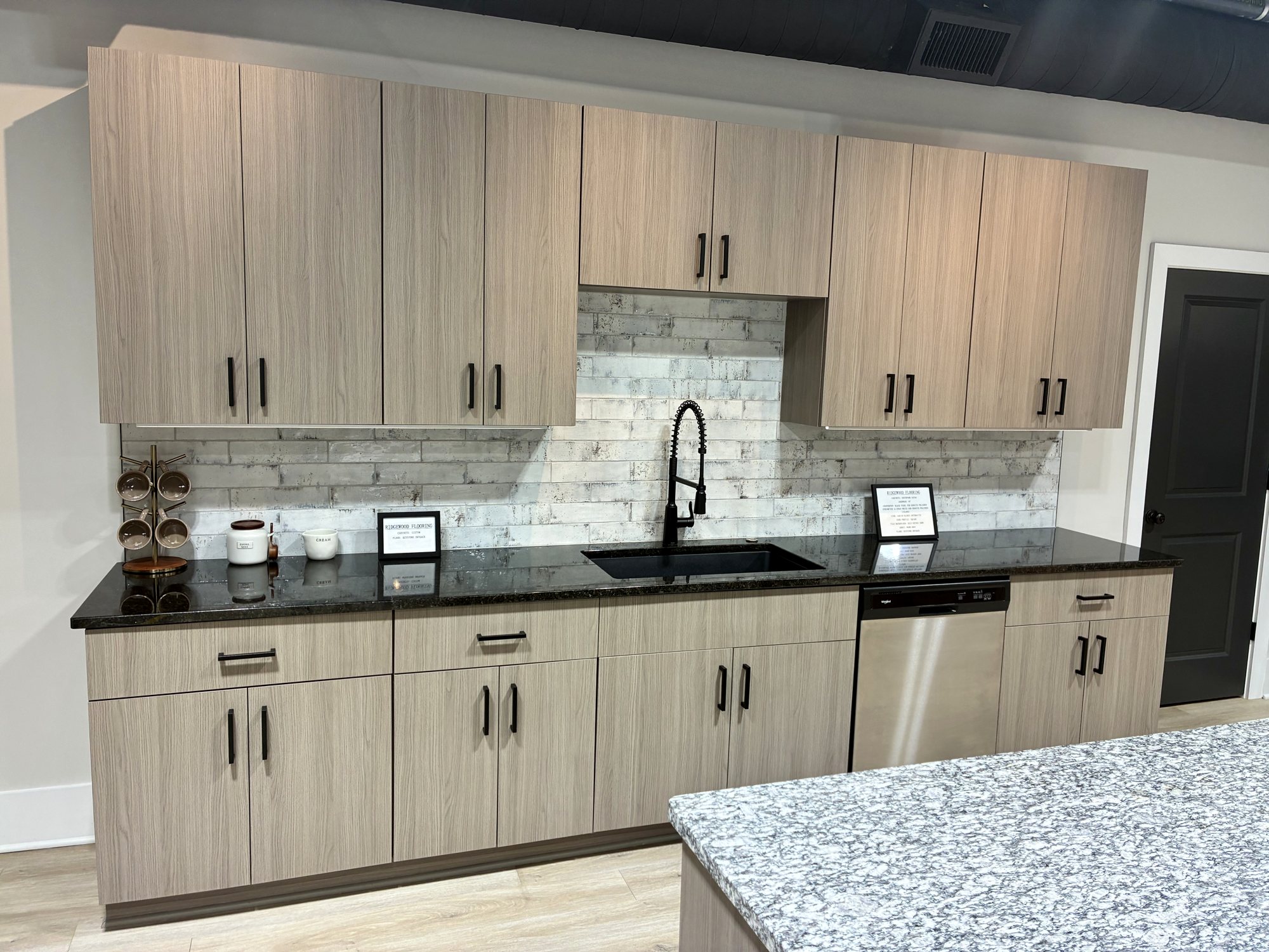 Kitchen vignette with woodgrain cabinetry and dark countertop