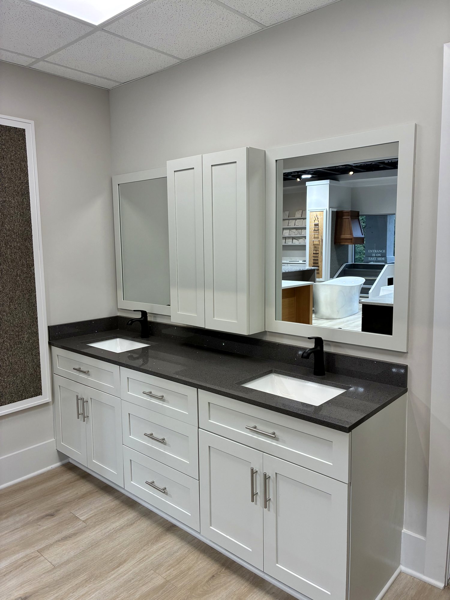 Vanity with dark countertop and mirror